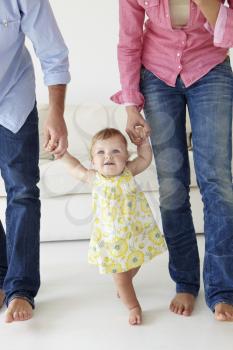 Parents teaching baby girl to walk