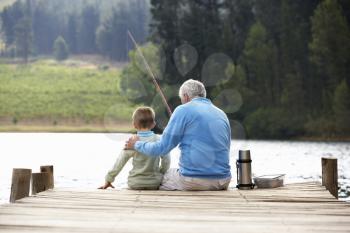 Senior man fishing with grandson