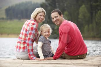 Young family sitting on a jetty