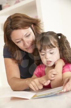 Mother and Downs Syndrome girl reading