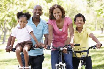 Family cycling in park