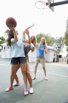 Group Of Young Women Playing Basketball Match