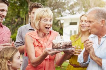 Multi Generation Family Celebrating Birthday In Garden