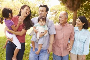 Multi Generation Family Walking In Park Together