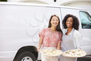 Woman Delivering Pizza Standing In Front Of Van