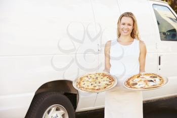 Woman Delivering Pizza Standing In Front Of Van