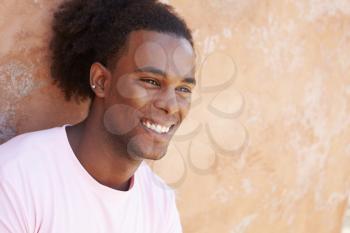 Portrait Of Smiling Man Leaning Against Wall