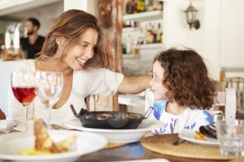 Mother And Daughter Enjoying Meal In Restaurant