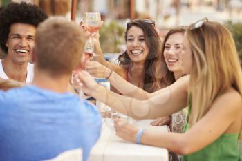 Group Of Young Friends Enjoying Meal In Outdoor Restaurant