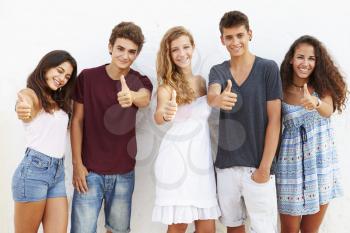 Teenage Group Leaning Against Wall Giving Thumbs Up