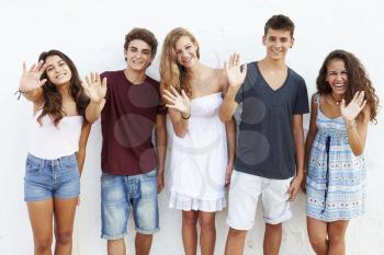 Teenage Group Leaning Against Wall Waving