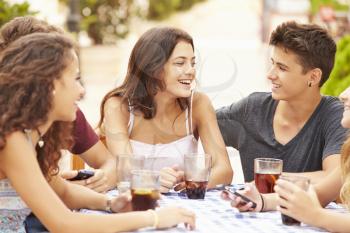 Group Of Teenage Friends Sitting Together At Caf