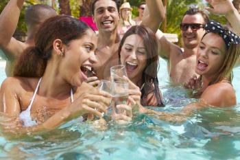 Group Of Friends Having Party In Pool Drinking Champagne