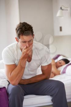 Man Sitting On Bed And Feeling Unwell