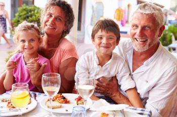 Grandparents With Grandchildren Eating Meal At Restaurant