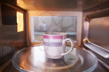 Warming Cup Of Coffee Inside Microwave Oven