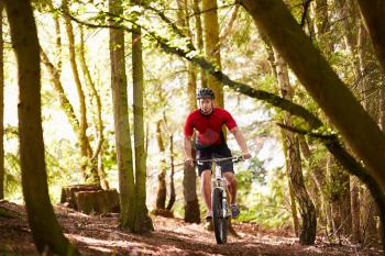 Man Riding Mountain Bike Through Woods