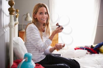 Woman In Bedroom Putting On Make Up In Morning