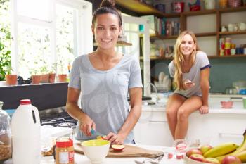 Two Female Friends Preparing Breakfast At Home Together