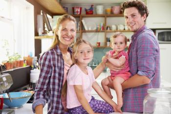 Portrait Of Family Cooking Meal In Kitchen Together