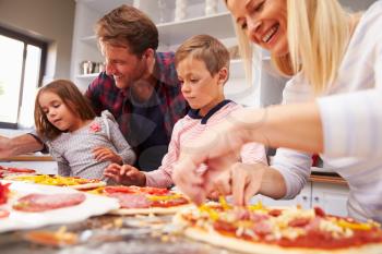 Family making pizza together