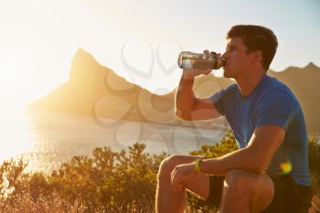 Young man drinking after jogging