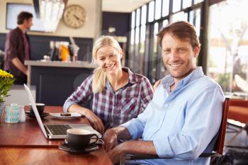 Man and woman with laptop at a coffee shop