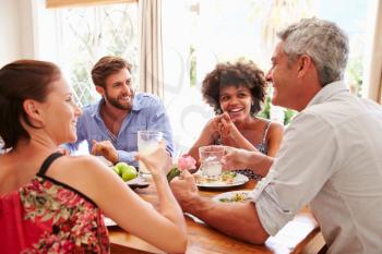 Friends sitting at a table talking during a dinner party