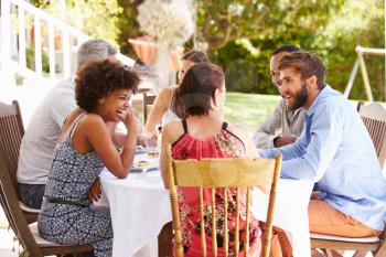 Friends dining together at a table in a garden