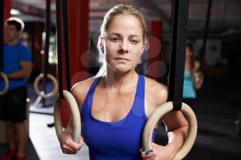Portrait Of Woman In Gym Exercising With Gymnastic Rings