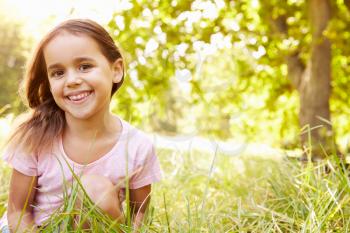 Portrait of a young girl sitting outdoors on a sunny day