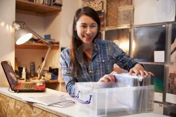 Young woman working behind the counter at a record shop