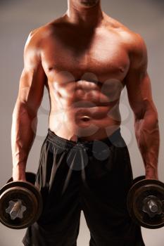 Male bodybuilder holding heavy dumbbells