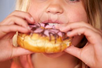 Close Up Of Girl Eating Iced Donut