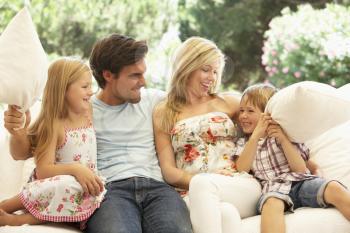 Portrait Of Young Family Relaxing On Sofa