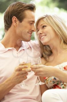 Portrait Of Young Couple Relaxing On Sofa Drinking Wine Together