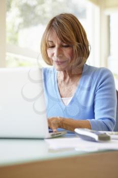 Senior Hispanic Woman Using Laptop In Home Office