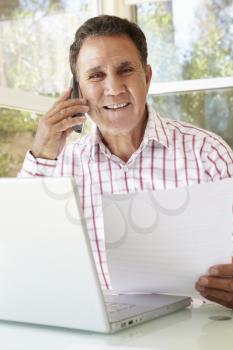 Senior Hispanic Man Working In Home Office