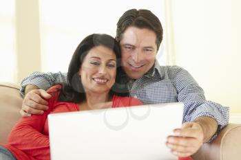Hispanic Couple Using Laptop At Home