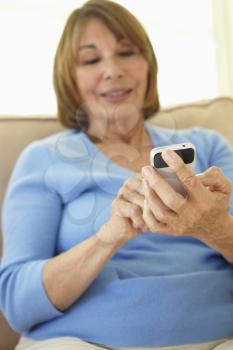 Senior Hispanic Woman Using Smartphone At Home
