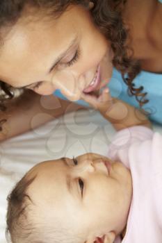 Mother Playing With Baby Daughter At Home