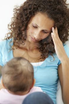 Stressed Mother At Home With Baby