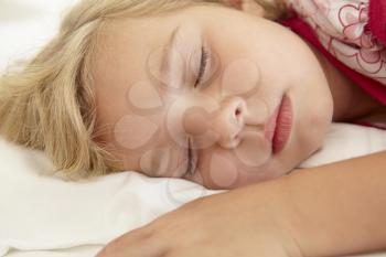 Young Girl Sleeping On Bed In Bedroom