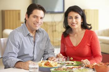 Young Hispanic Couple Enjoying Meal At Home