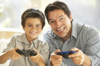 Father And Son Playing Video Game At Home