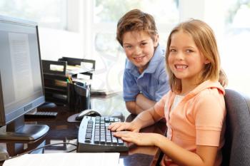 Young boy and girl using computer at home