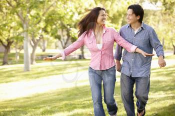 Asian couple running through in park