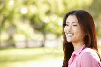 Head and shoulders portrait Asian woman outdoors