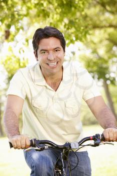 Young Hispanic Man Cycling In Park