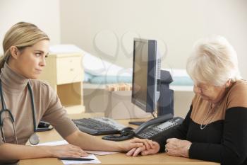 Doctor reassuring senior woman patient